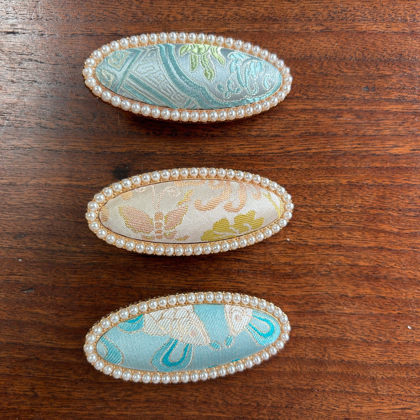 JOFAE Kyoto handmade brocade oval hair clip with pearl frame, showcasing elegant, intricate fabric and a delicate pearl accent.